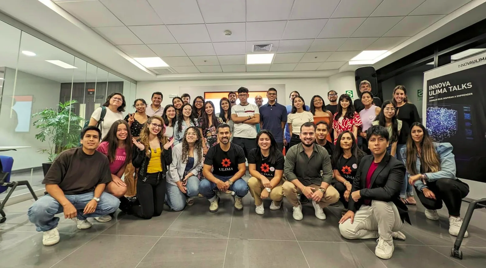 Foto grupal de participantes de Innova Ulima junto al cartel de Innova Ulima Talks